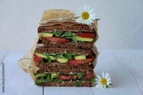 delicious sandwiches stacked on the white table. with early daisies. early in the morning photo
