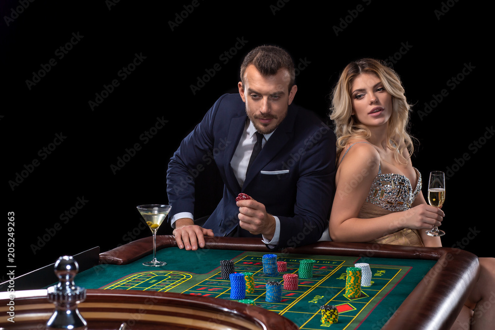 Couple gambling at roulette table in casino Couple gambling at roulette table in casino