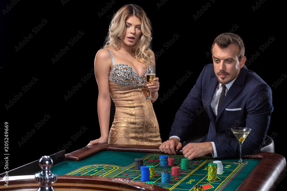 Couple gambling at roulette table in casino Couple gambling at roulette table in casino