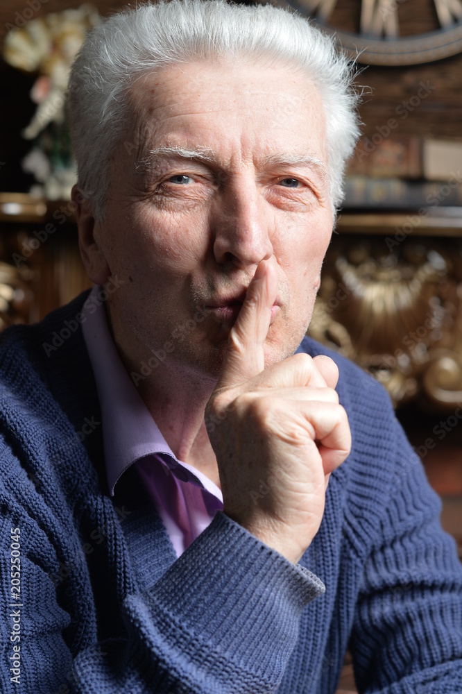 Senior man with finger on lips gesturing silence Senior man with finger on lips gesturing silence