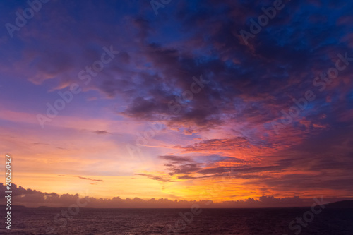 summer sunset colorful sky with dramatic  purple red and yellow clouds over picturesque water landscape. Bali, Indonesia. © Arsenii