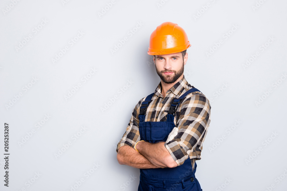 Portrait with copyspace of attractive handsome repairer in shirt and overall looking at camera isolated on grey background, having arms crossed, isolated on grey background Portrait with copyspace of attractive handsome repairer in shirt and overall looking at camera isolated on grey background, having arms crossed, isolated on grey background