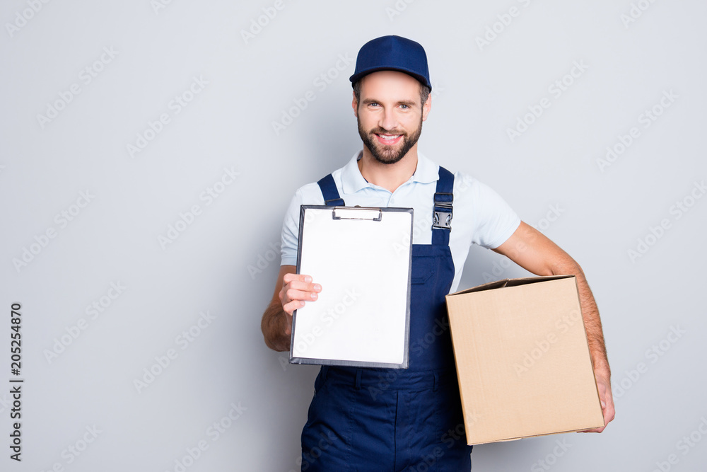 Portrait with empty place, copyspace of cheerful, attractive man having, carrying box in hands demonstrate clean paper in clipboard, looking at camera, isolated on grey background Portrait with empty place, copyspace of cheerful, attractive man having, carrying box in hands demonstrate clean paper in clipboard, looking at camera, isolated on grey background