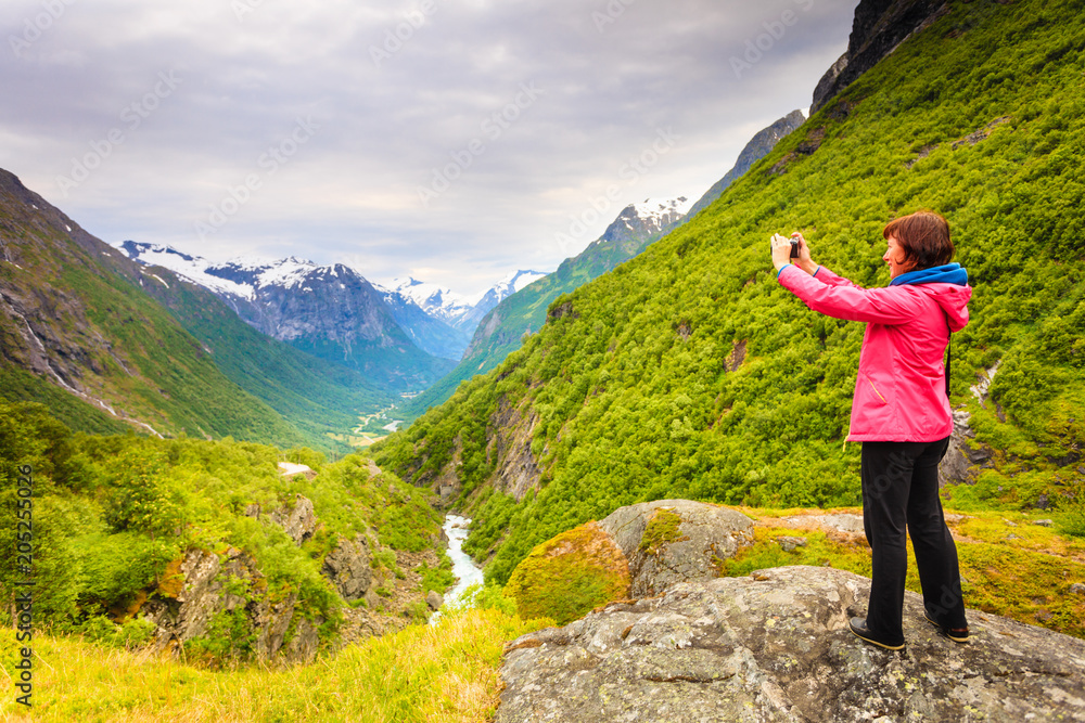 Tourist with camera taking picture in mountains Norway