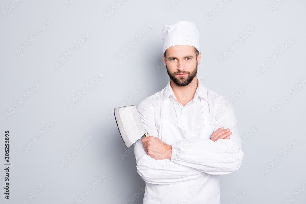 Portrait of handsome attractive butcher in beret having his arms crossed holding metal cleaver looking at camera isolated on grey background Portrait of handsome attractive butcher in beret having his arms crossed holding metal cleaver looking at camera isolated on grey background