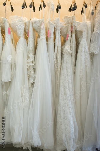 white wedding dresses hanging on racks