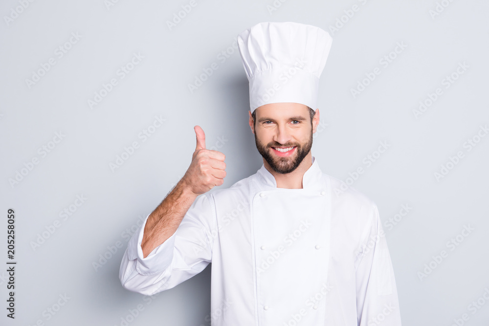 Portrait of cheerful joyful chef cook with stubble in beret, white outfit showing thumb up, approve menu, yes, done sign isolated on grey background, advertisement concept Portrait of cheerful joyful chef cook with stubble in beret, white outfit showing thumb up, approve menu, yes, done sign isolated on grey background, advertisement concept