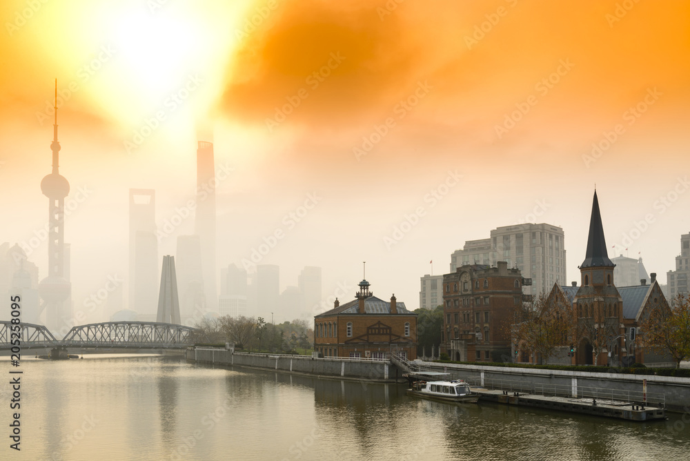 Shanghai Financial Center and modern skyscraper city in misty gold lighting sunrise behind pollution haze, view from the bund in Shanghai, China. vintage picture style