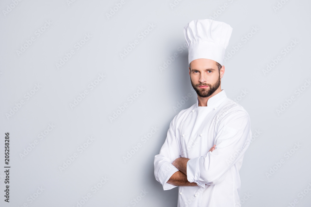 Portrait with copy space, empty place for advertisement, product of harsh virile chef cook with stubble in beret, white outfit having his arms crossed, isolated on grey background
