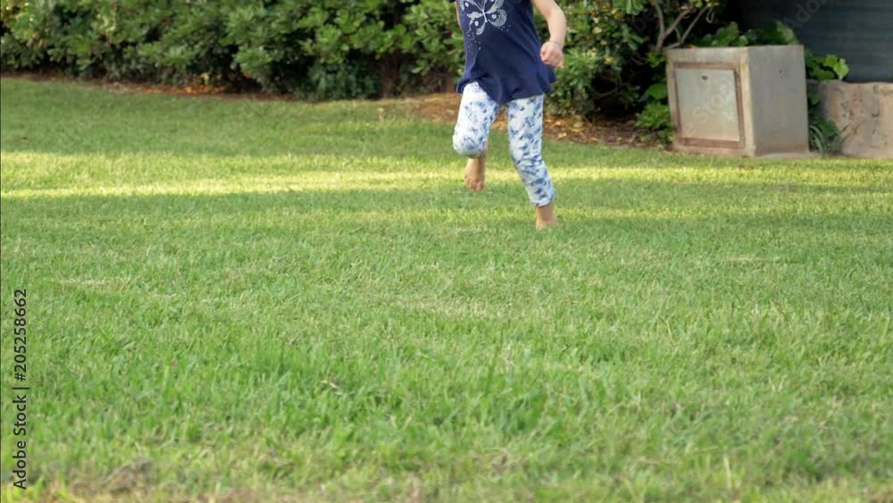 Cute little girl runnin in park slow motion at sunset side shot Cute little girl runnin in park slow motion at sunset side shot