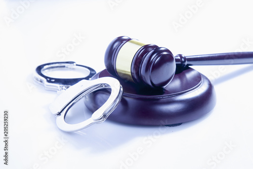 Judge gavel and handcuffs on white background as a symbol of justice and punishment
