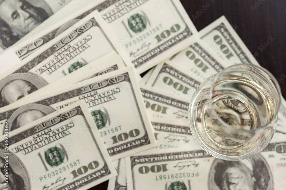 Fototapeta premium Exclusive Scott and Japanese whisky with dollars bank notes on wooden table in luxury bar, tip for good service. Film tones conception.
