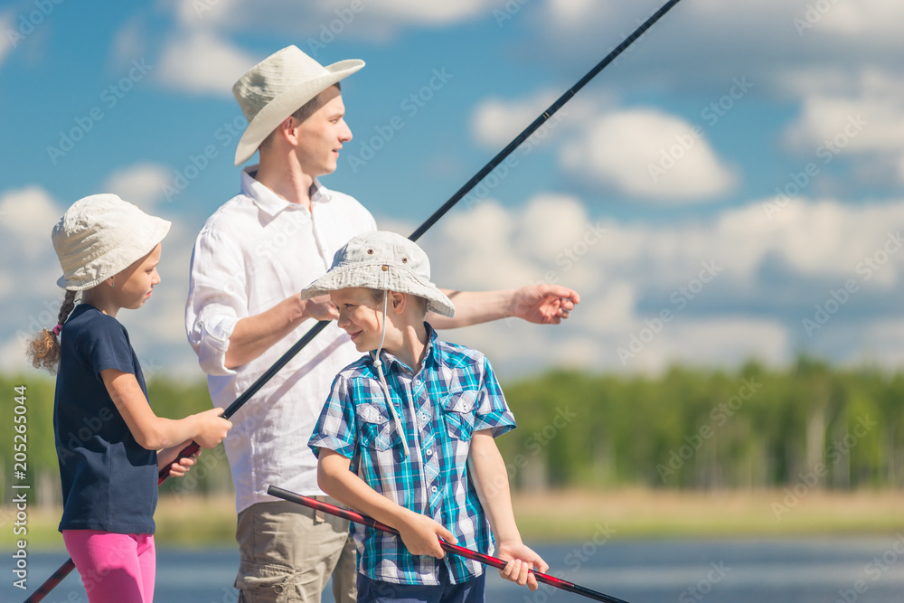 The brother and sister with the father on fishing with fishing rods a summer day The brother and sister with the father on fishing with fishing rods a summer day