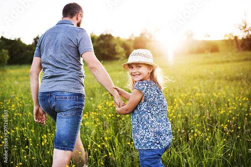 Father with a small daughter on a walk in spring nature.