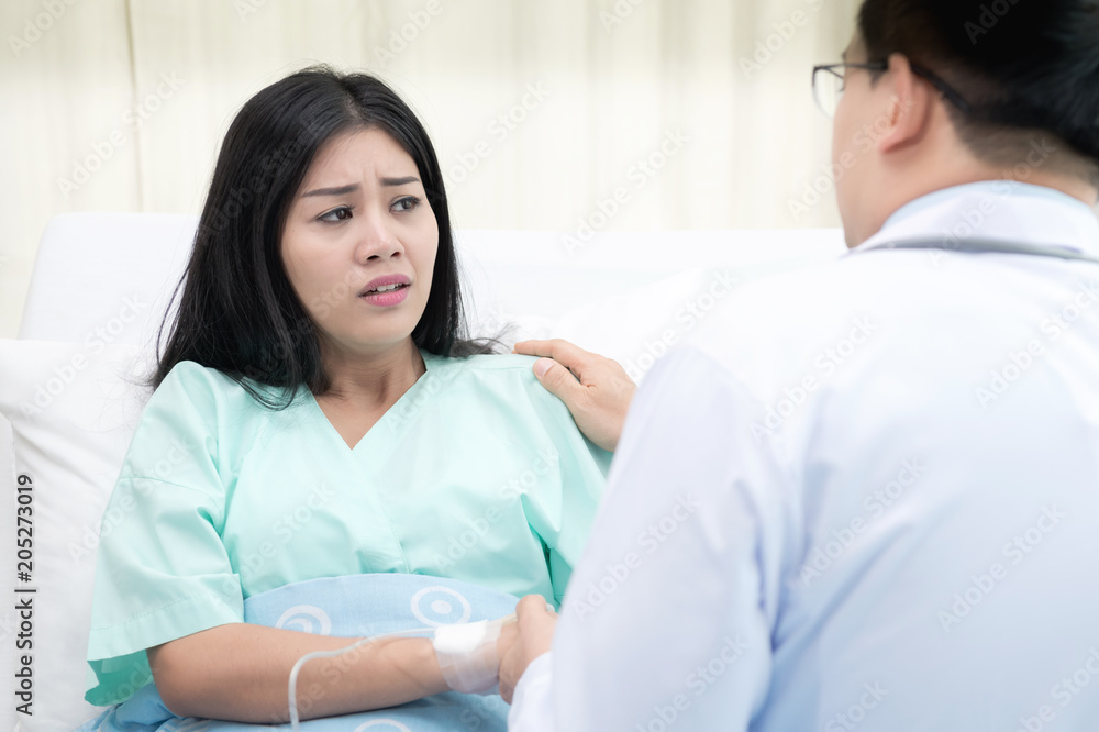 Doctor with patient. Routine health check and holding hands. Male medical doctor with young chinese woman. Doctor with patient. Routine health check and holding hands. Male medical doctor with young chinese woman.