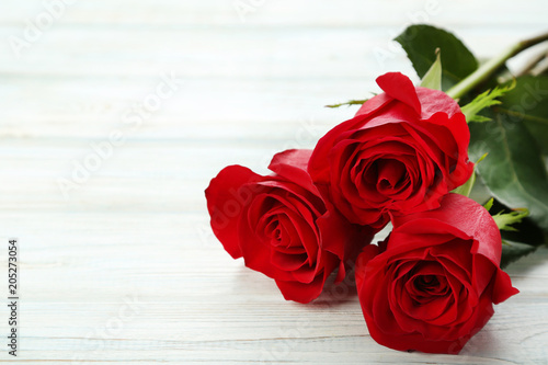 Bouquet of red roses on white wooden table