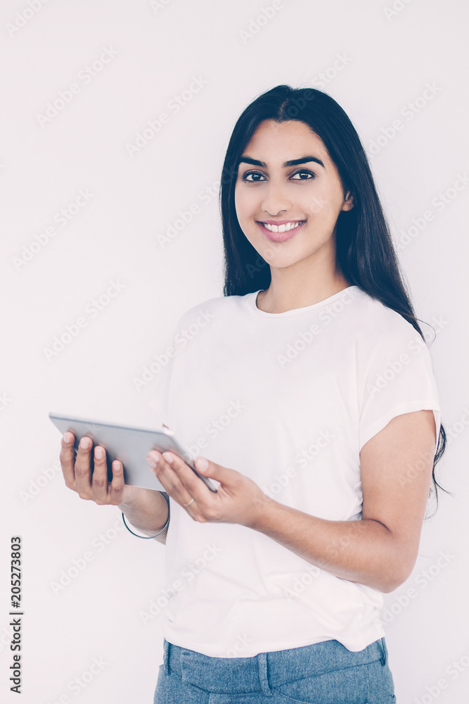 Closeup portrait of smiling young beautiful Indian woman looking at camera  and holding tablet PC. Isolated view on white background. Stock Photo |  Adobe Stock