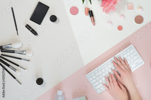 Flat lay and top view of make up products on white pink background with copyspace. Beauty concept for blogger, pastel women business office table desk photo