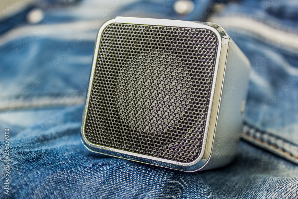 music concept with small loud speaker on jeans texture with empty space for copy or text music concept with small loud speaker on jeans texture with empty space for copy or text