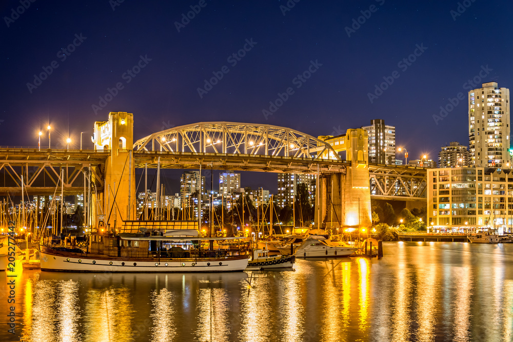 Burrard Bridge Vancouver at night with sail boats and motor boats