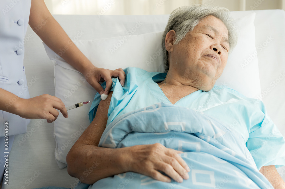 Nurse with patient. Routine health check and doing medical injection. Female nurse with senior chinese woman. Nurse with patient. Routine health check and doing medical injection. Female nurse with senior chinese woman.