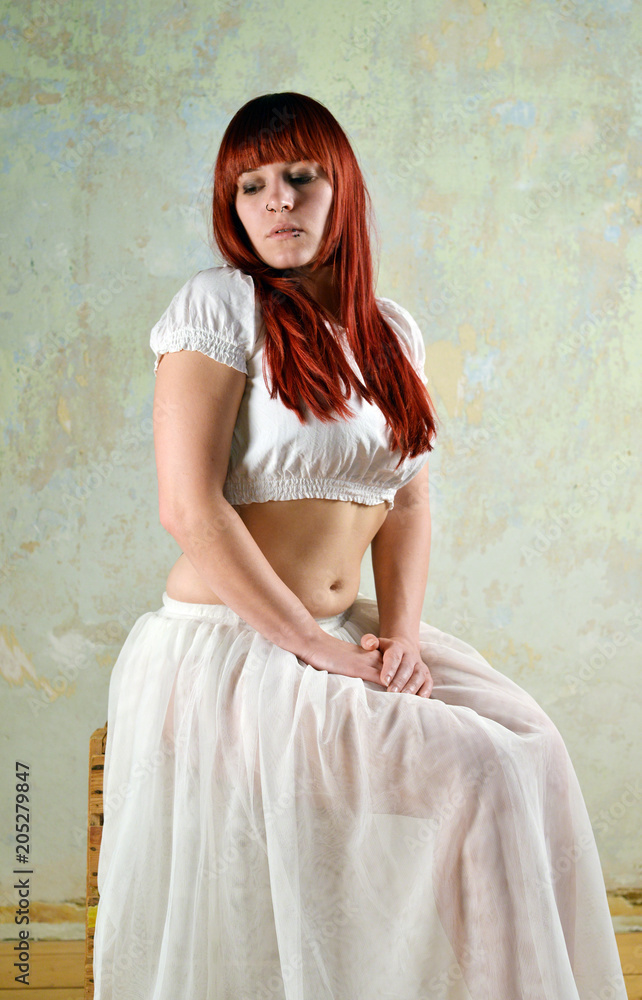 Fototapeta premium Frau mit hellem Kleid und roten Haaren