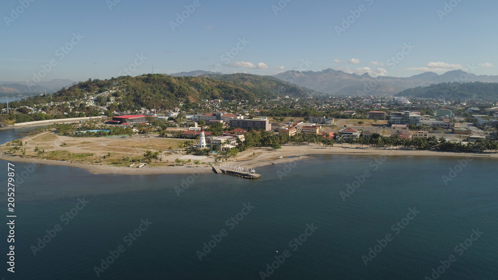 Obraz premium Linia brzegowa z plażą i latarnią morską, góry. Widok z lotu ptaka: Wybrzeże morskie z hotelami, kurortami, zatoką Subic, Filipiny, Luzon
