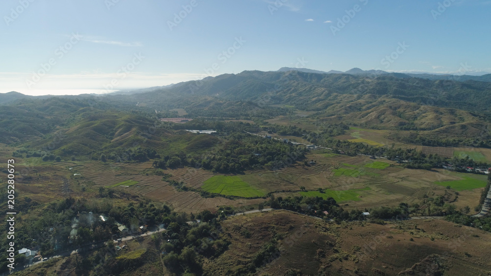 Mountain valley with village, farmland in the Philippines, Luzon. Aerial view: Mountain valley with green trees and river. Mountain valley with village, farmland in the Philippines, Luzon. Aerial view: Mountain valley with green trees and river.
