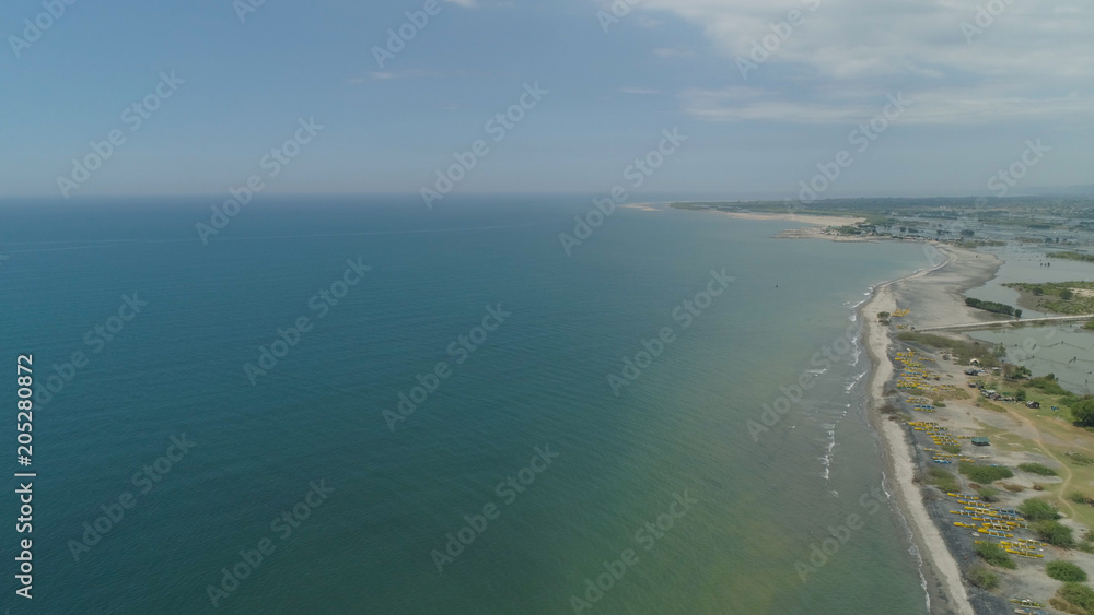 Aerial view of coastline with sandy beach, azure water on the island Luzon, Philippines. Seascape, ocean and beautiful beach. Agoo Damortis National Seashore Park.