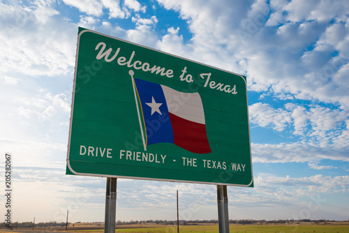 Welcome to Texas road sign in front of cloudy sky photo