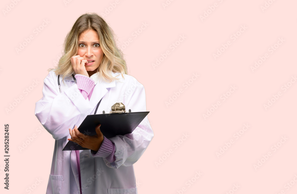 Fototapeta premium Young doctor woman, medical professional terrified and nervous expressing anxiety and panic gesture, overwhelmed
