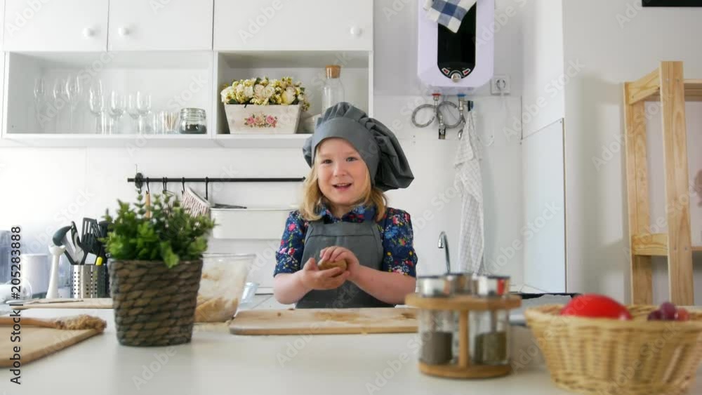 Little girl baker rolls out the dough and talking Little girl baker rolls out the dough and talking