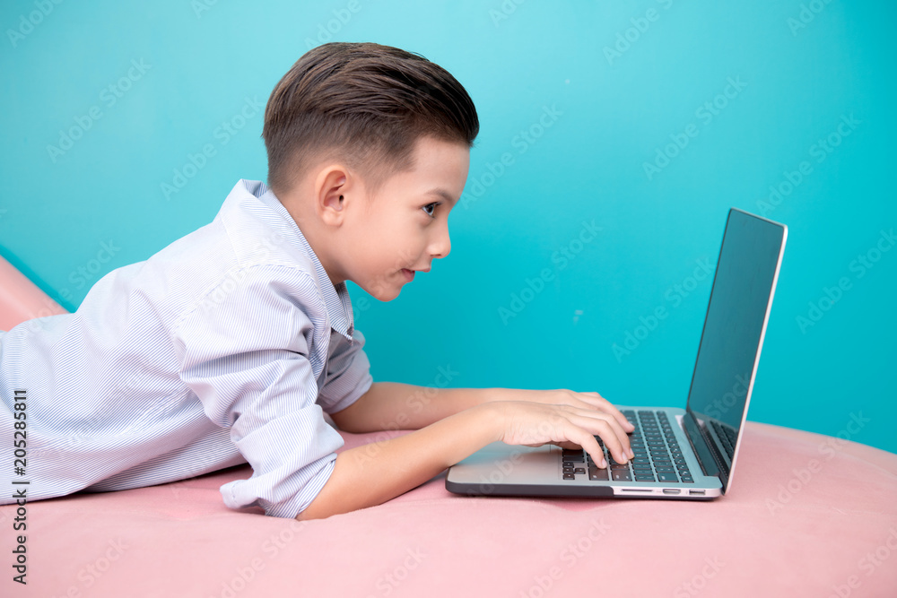 Young software programmer isolated in blue. Handsome early teenage boy portrait. Playing with notebook. Technology concept. Young software programmer isolated in blue. Handsome early teenage boy portrait. Playing with notebook. Technology concept.