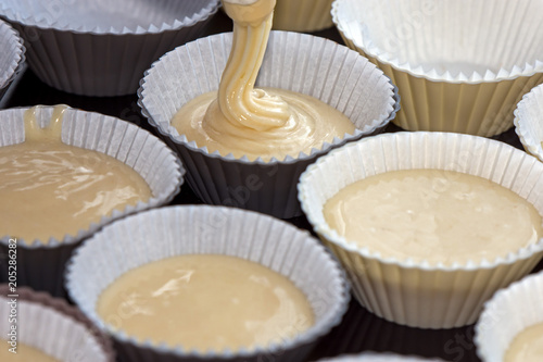 making muffins, filling the cups with batter