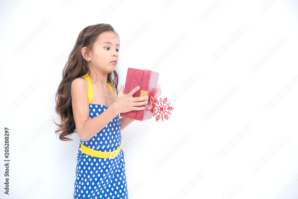Young girl got suprise gift. Young cute white girl holding a red gift present box, looking funny and surprise. Isolated in white. Birthday girl and family concept. Young girl got suprise gift. Young cute white girl holding a red gift present box, looking funny and surprise. Isolated in white. Birthday girl and family concept.