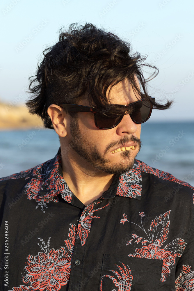 Ugly man thinking he's pretty in glasses and flowery shirt doing selfie on the beach Stock-foto | Stock