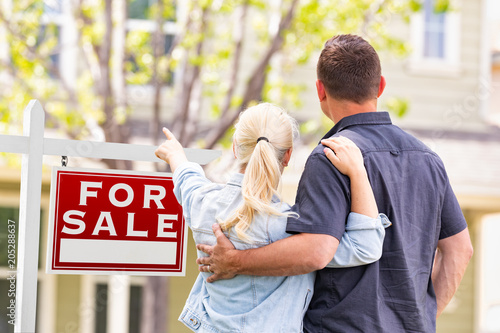 Foto Caucasian Couple Facing and Pointing to Front of For Sale Real Estate Sign and H