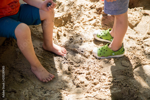Cute kindegarteners feet in a sandbox