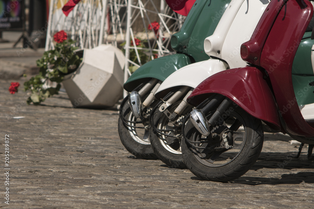 three mopeds painted in colors of the Italian flag