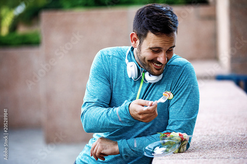 Man is eating vegetable salad photo