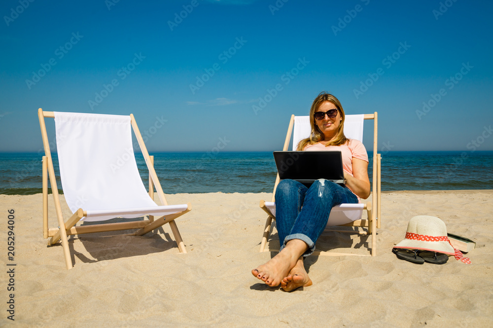 Woman with laptop on beach