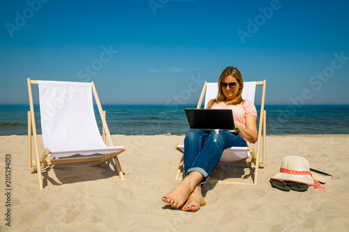 Woman with laptop on beach