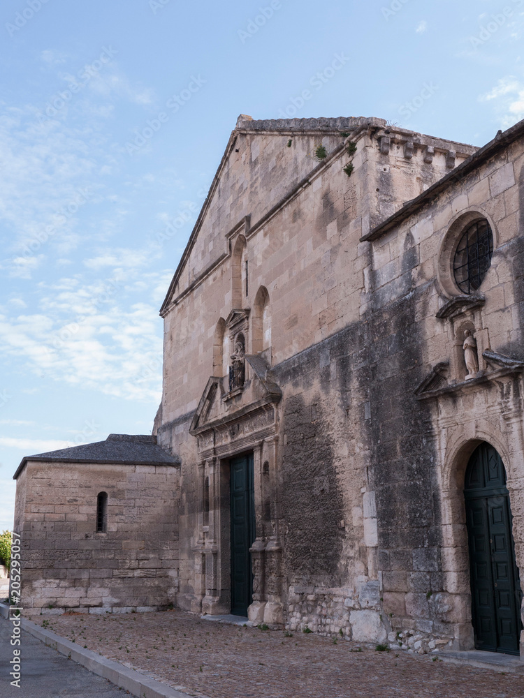 old church against blue sky and white clouds, Arles, France