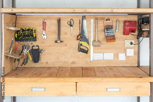 Wooden workbench at workshop. Lot of different tools for diy and repair works. Wood desk for product placement. Copyspace. Labour day photo