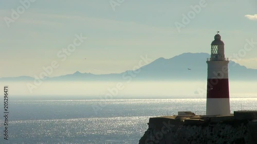 Gibraltar Lighthouse, Bright Sea and Birds Flying