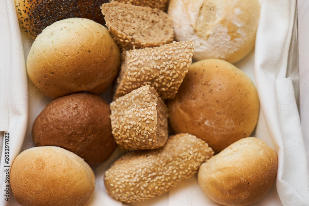 Variety of sliced bread in basket, close-up. A lot on mixed bun, top view 