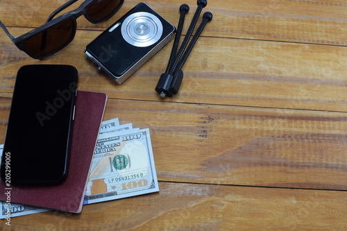 going on vacation (travel), on the table is a passport with money (dollars), glasses, camera