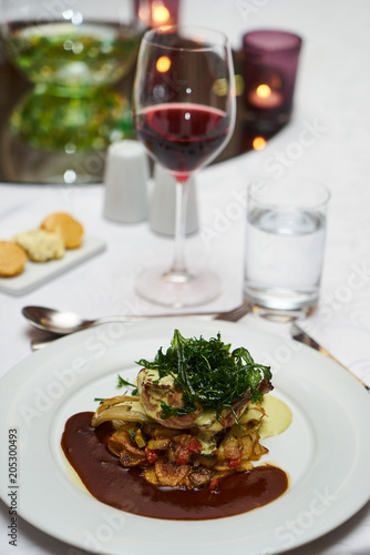 People eating roasted organic chicken dish with tarragon, mustard sauce, rosemary, potatoes tian and confit fennel, close-up. Delicious healthy food dinner on serving table concept