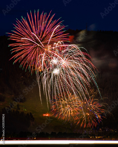 JACKSON HOLE WYOMING FOURTH OF JULY FIREWORKS OVER SKI HILL AND BLURRED HEADLIGHTS