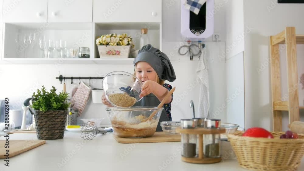 Little girl adds ingredients to the pastry dough Little girl adds ingredients to the pastry dough